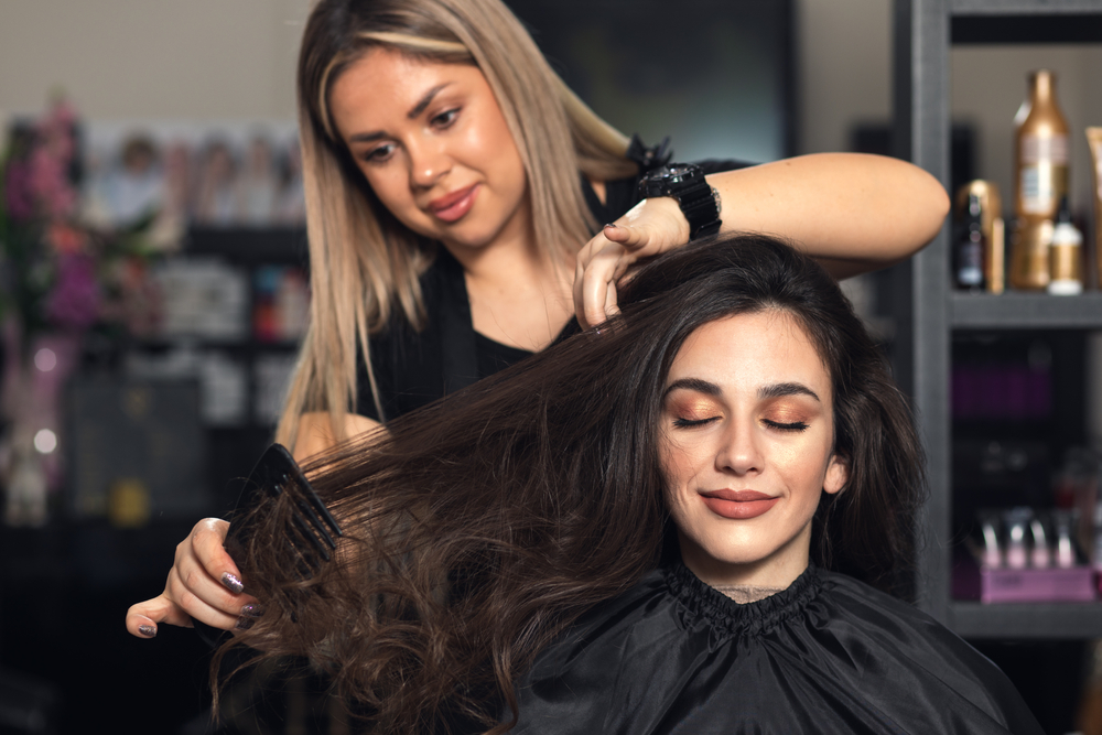 stylist straightening a clients hair